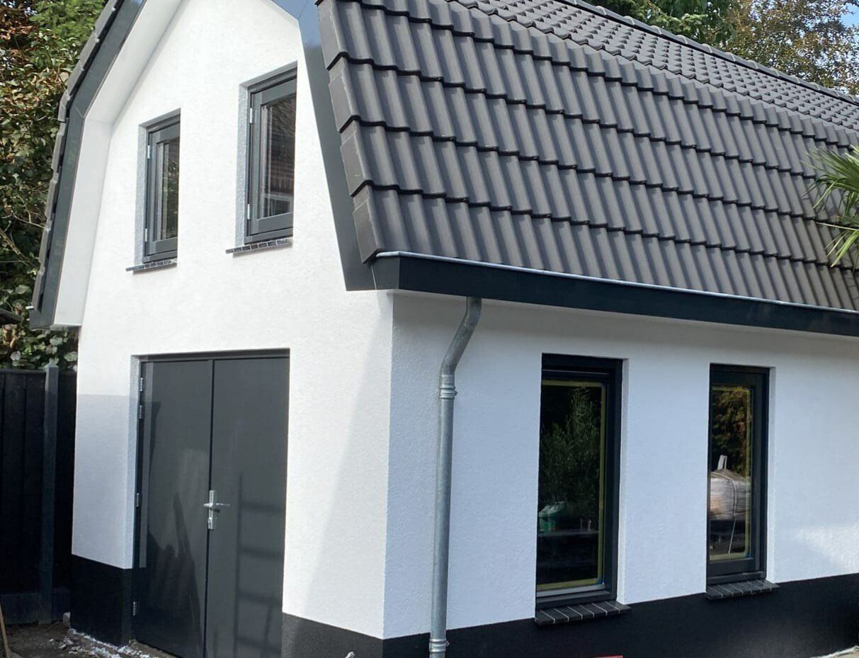 Witte huis met zwart dak detail. Gerenoveerde gevel verbouwing.