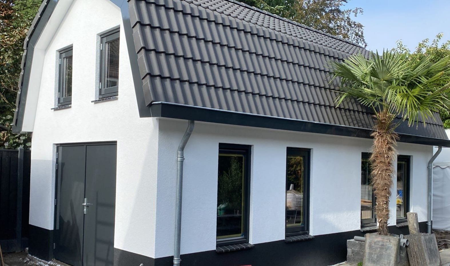 Moderne witte gevel zwart dak. Voorgevel renovatie