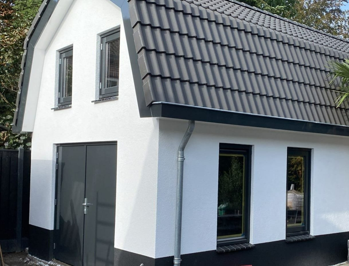 Moderne witte woning donker dak. Renovatie verbouwing nieuwbouw.