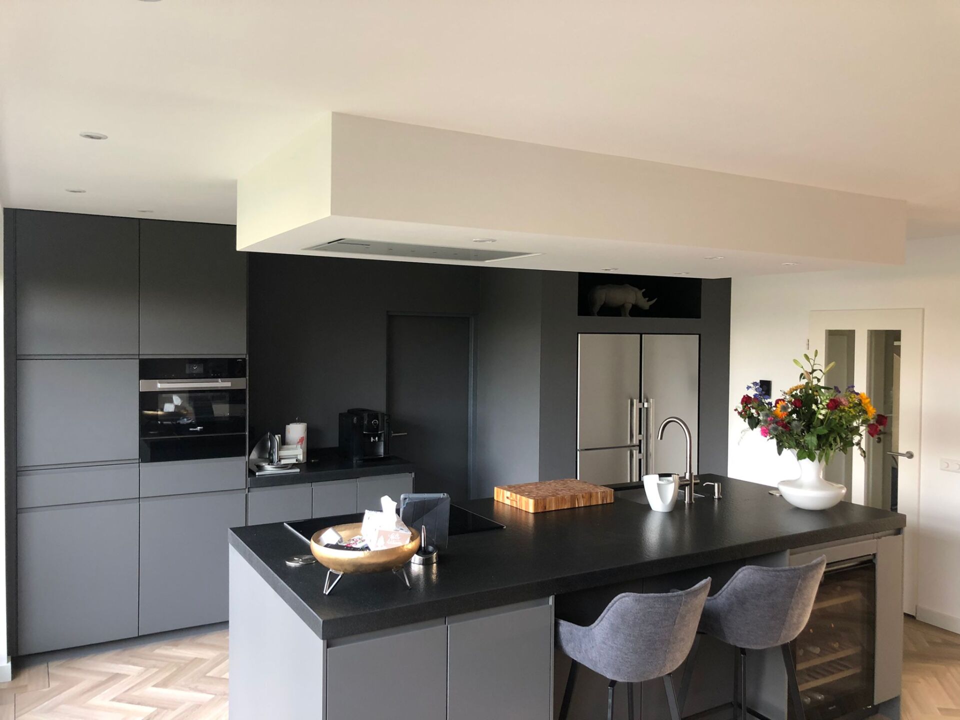 Moderne gerenoveerde keuken en eetkamer. Zwarte keukenkasten en eiland verbouwing.