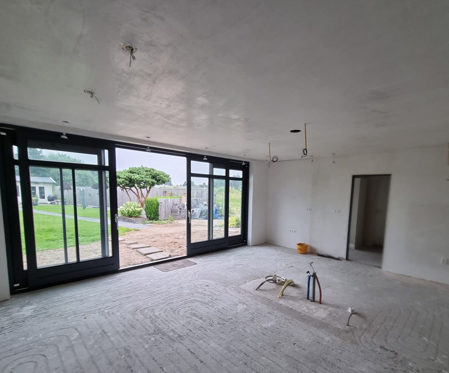 Aanbouw met grote glazen deuren. Keuken en eetkamer voor verbouwing van woning gerenoveerd.