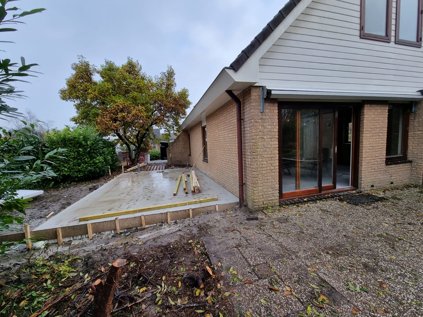 Betonnen terras fundering en bakstenen huis. Terrasverbouwing en renovatie buitenruimte.
