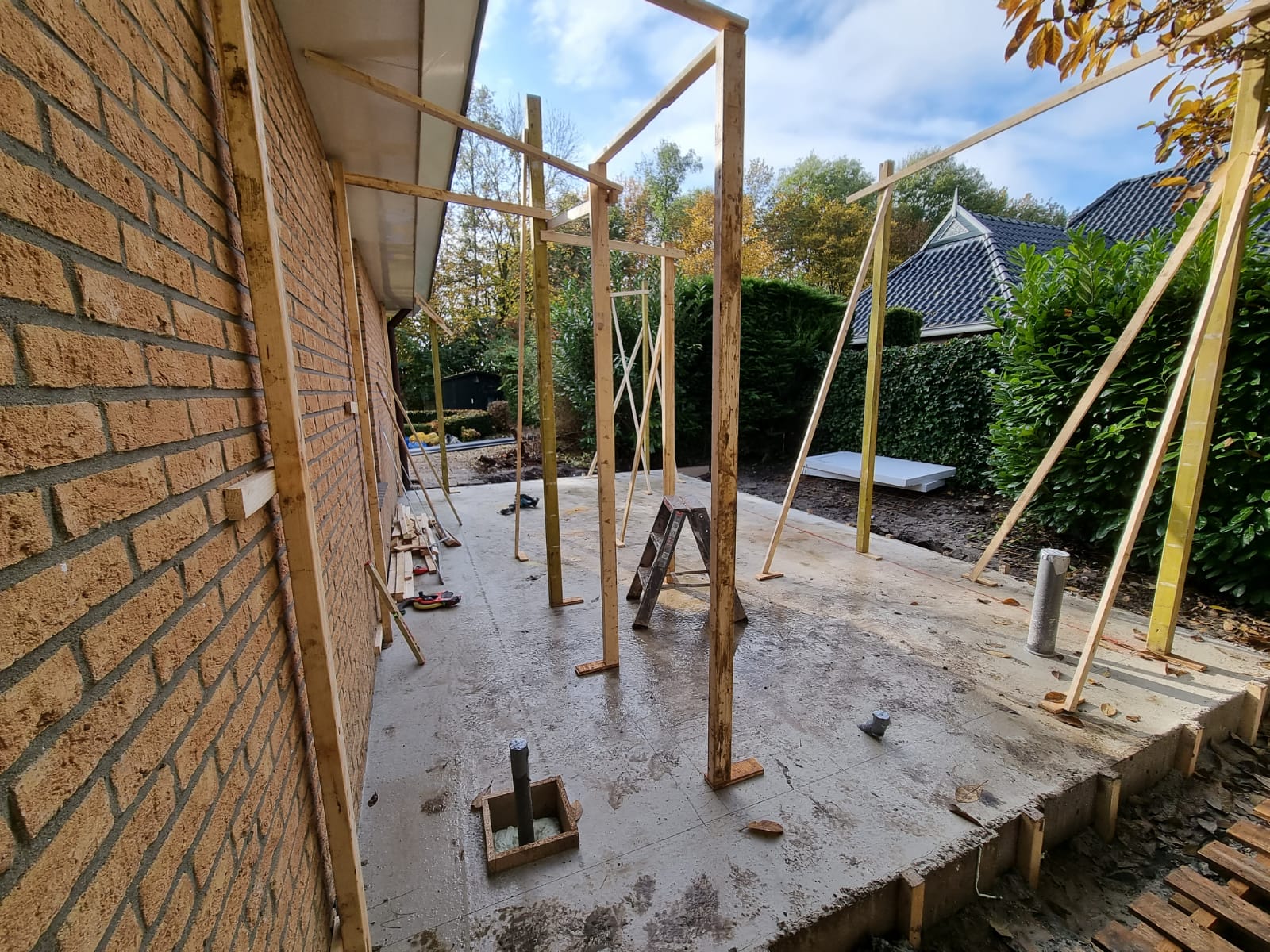 Houten pergola afdak in constructie fase. Afdakverbouwing en terrasrenovatie.