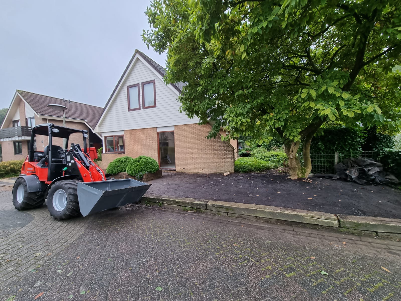 Huis met graafmachine grondwerk. Verbouwing aanbouw en renovatie bouwwerkzaamheden.