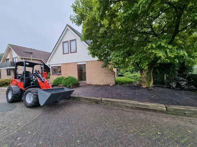 Terrasvoorbereiding met materieel. Rode wiellader op oprit voor terrein werk.