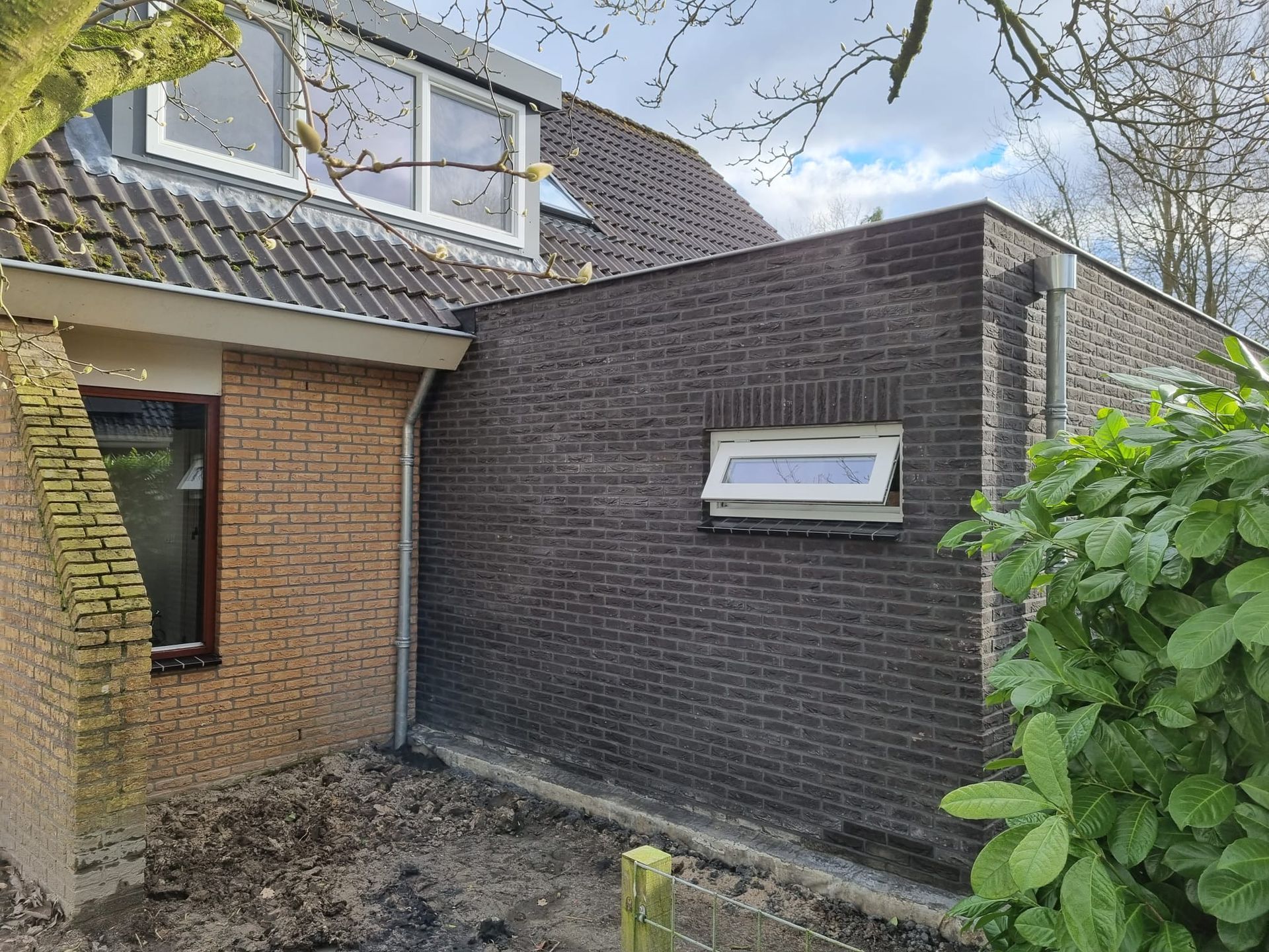 Bakstenen aanbouw aan bakstenen woning. Moderne aanbouw verbouwing en renovatie.