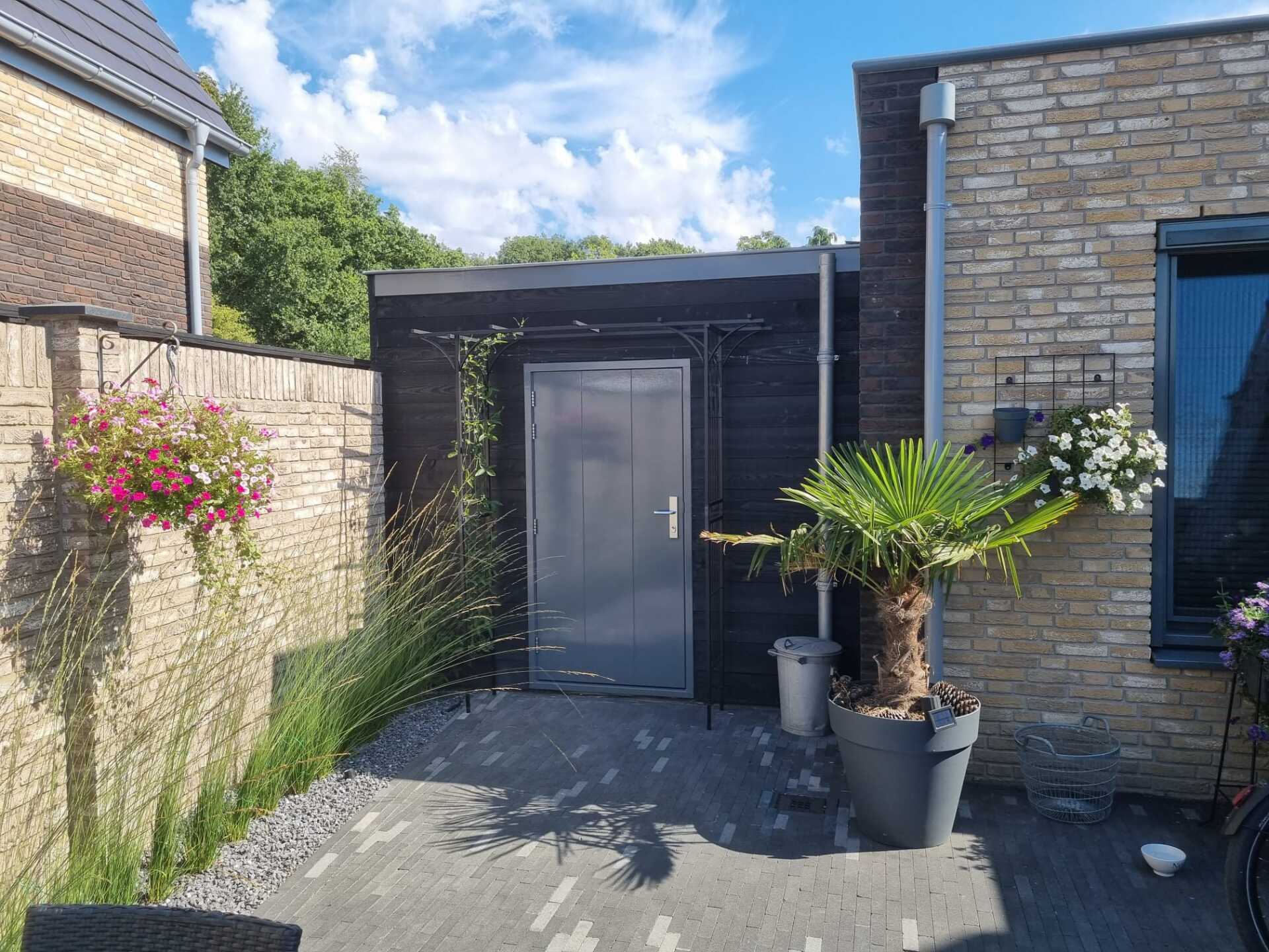 Moderne carport donkere deur. Ingang voorkant verbouwing