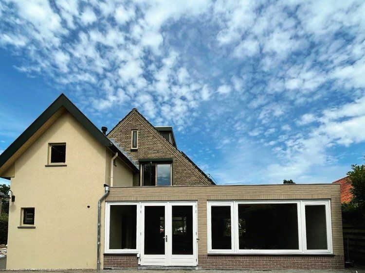 Witte bakstenen huis met aangeboorde garage. Voorgevel renovatie