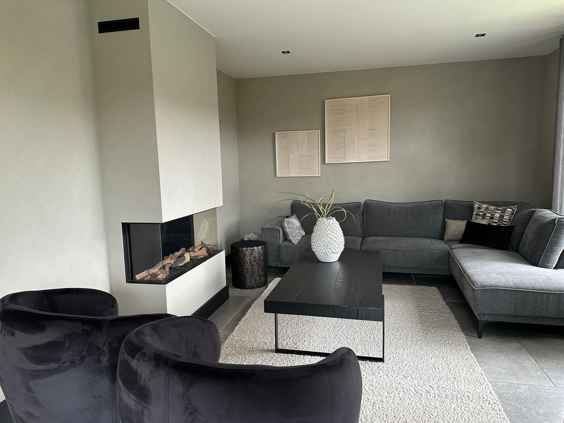 Woonkamer na renovatie met haard en moderne inrichting