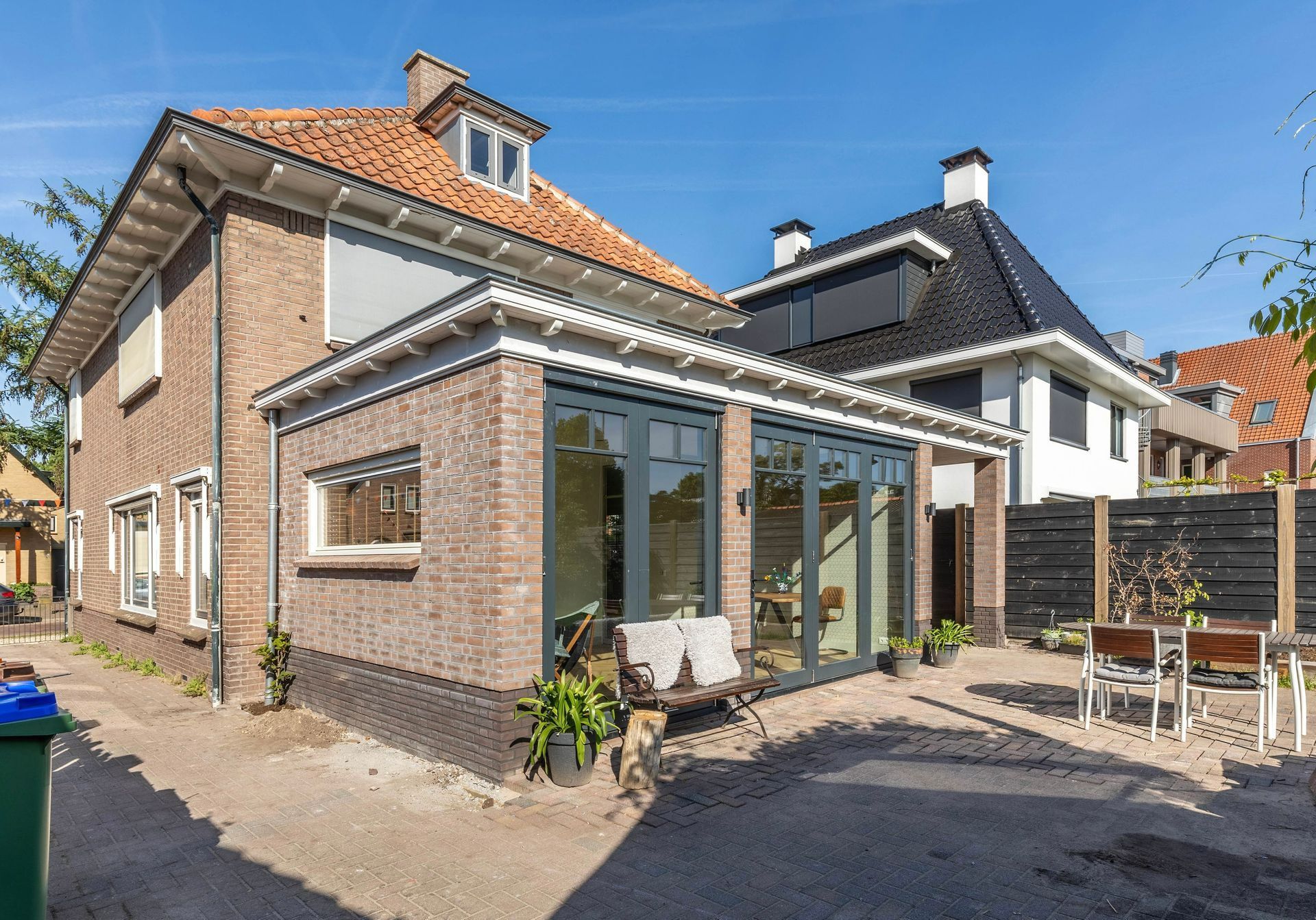 Gerenoveerd huis met aanbouw en grote ramen. Moderne verbouwing woning.
