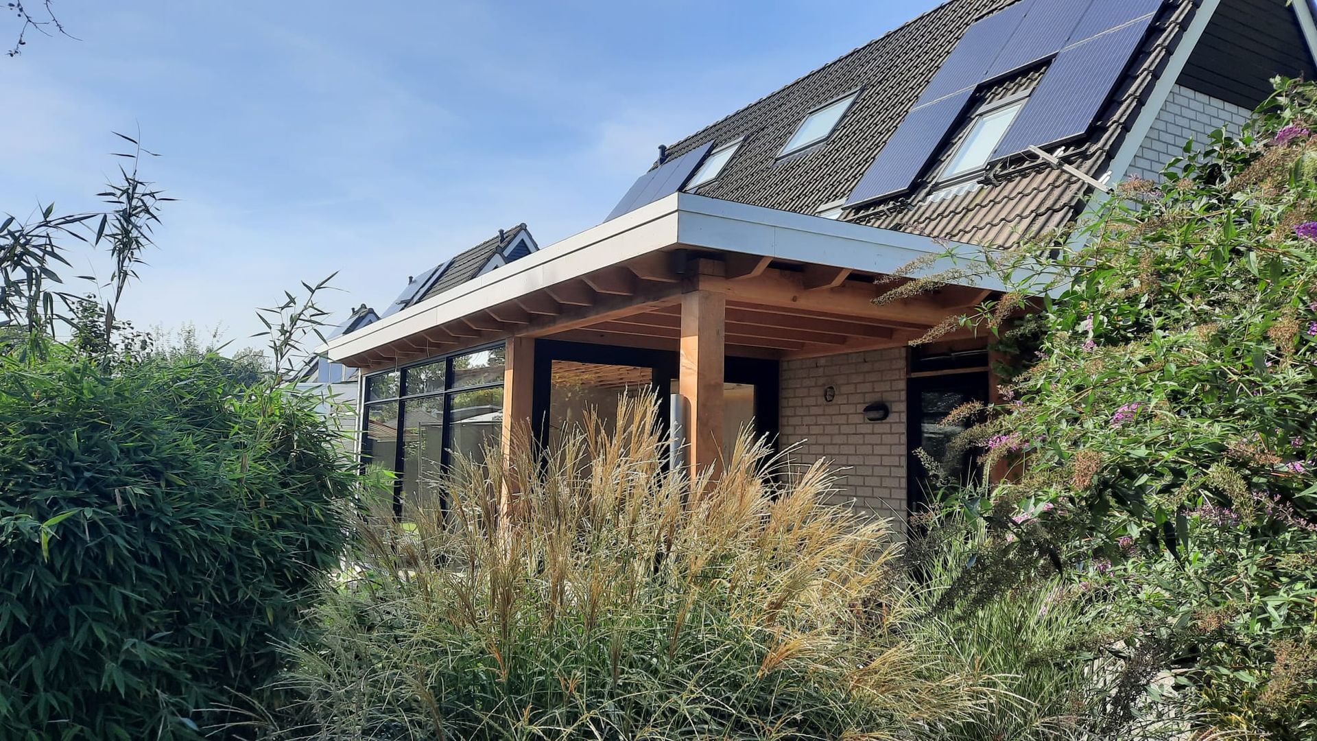 Moderne houten aanbouw aan bakstenen woning. verbouwing en uitbreiding.