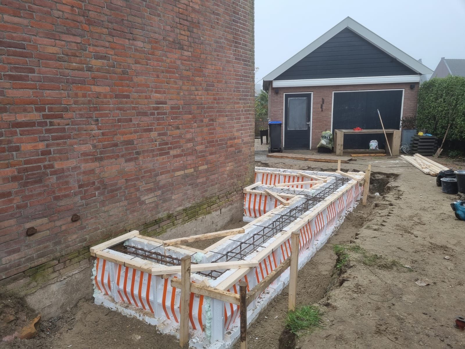 Bakstenen huis garage aanbouw. Verbouwing project voorkant.