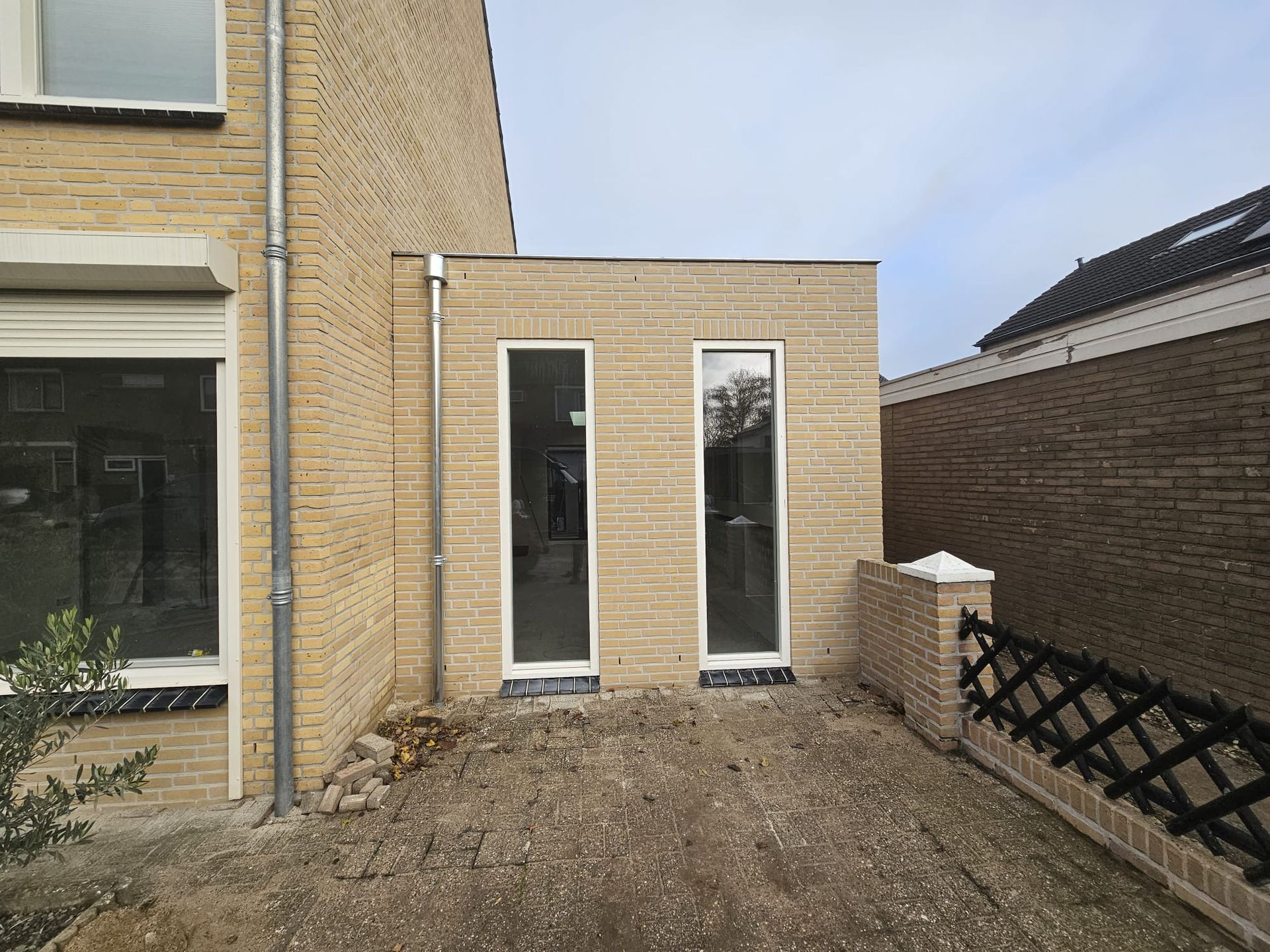 Tuinaanbouw bakstenen gevel. Woninguitbreiding moderne deuren