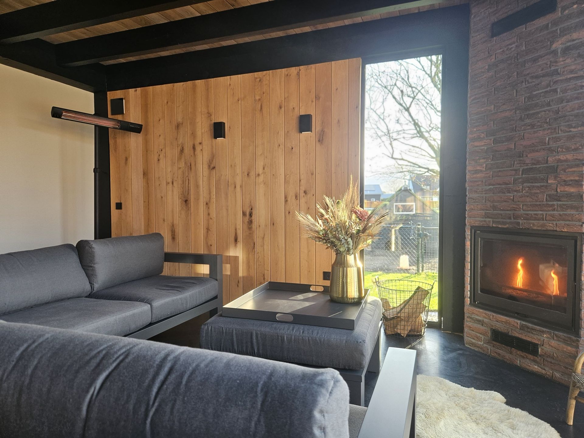 Moderne woonruimte aanbouw met houten details en haard. Woningrenovatie en aanbouwwerk.