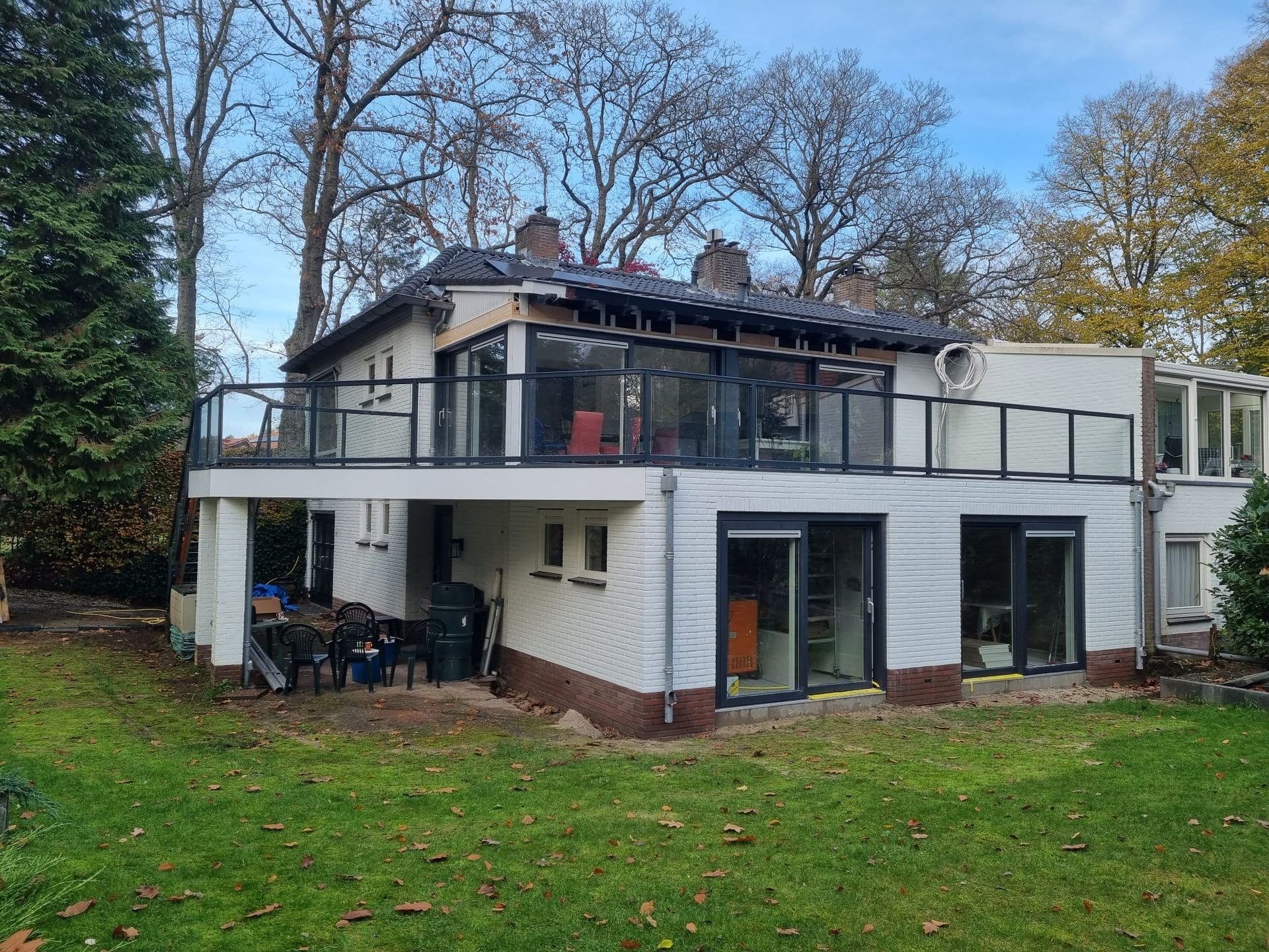 Modern twee verdiepingen huis met grote ramen. Verbouwing woning en aanbouw renovatie.