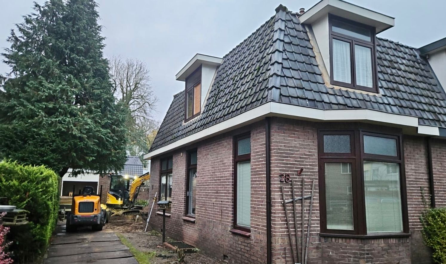 Dakkapel verbouwing voorbereiding. Woningverbouwing uitgraving bouwmachines