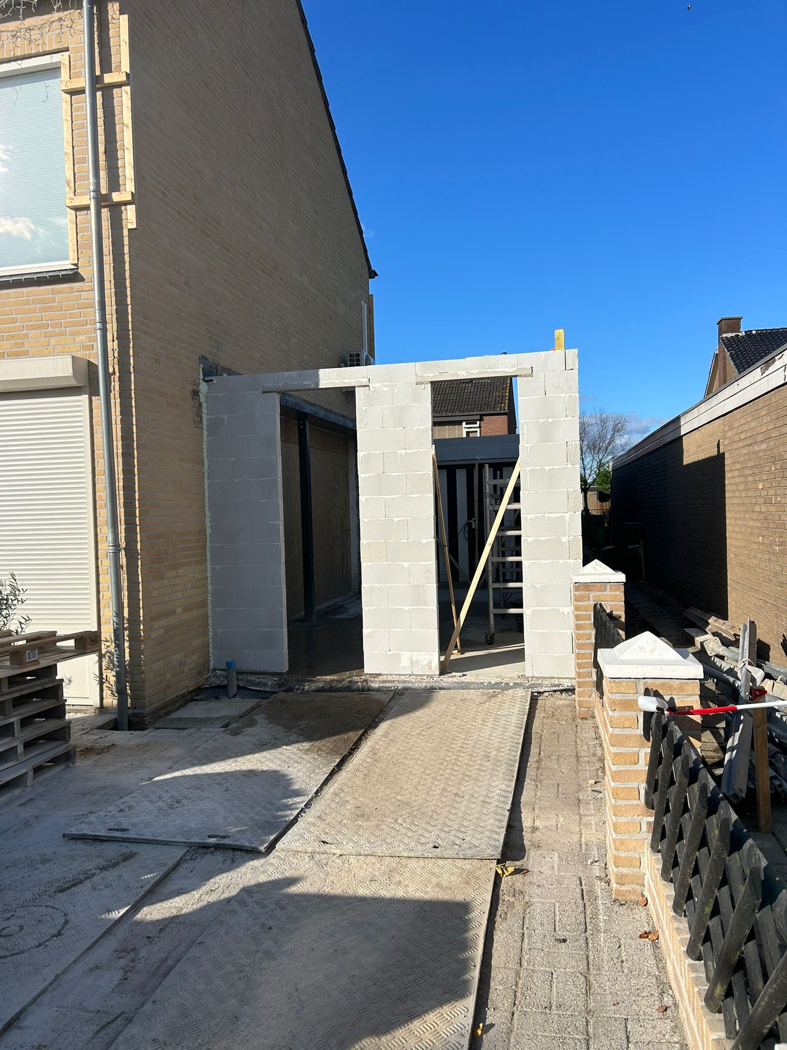Woning voortuin aanbouw. Tuinhuis verbouwing gevelwerk bakstenen