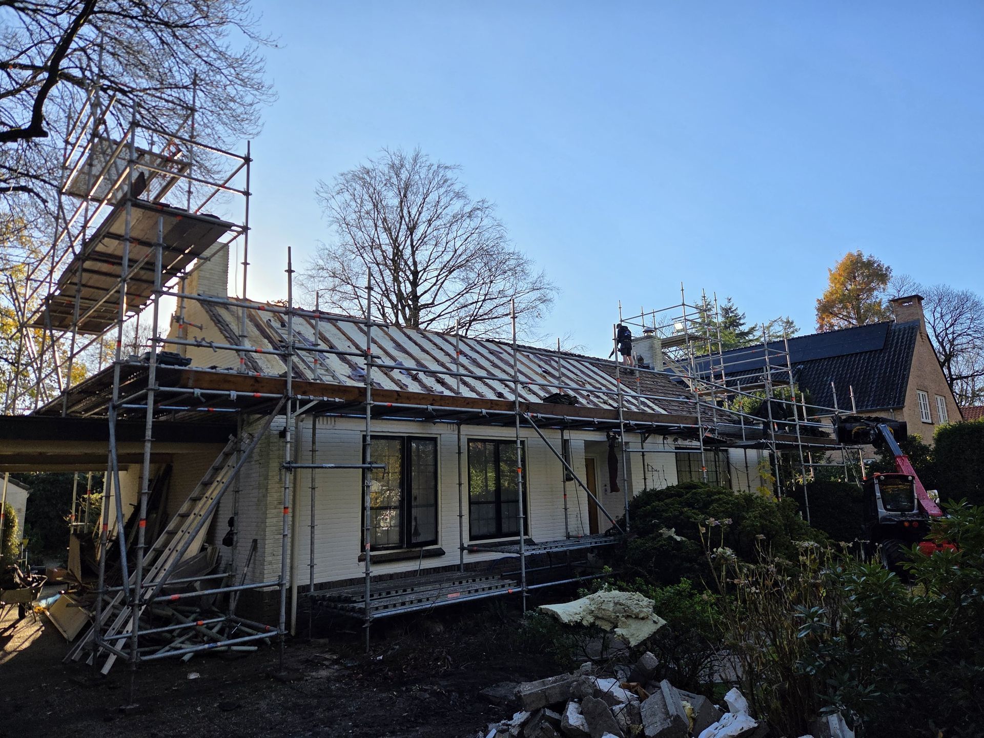 Woning tijdens dakrenovatie met steiger en nieuwe dakbedekking