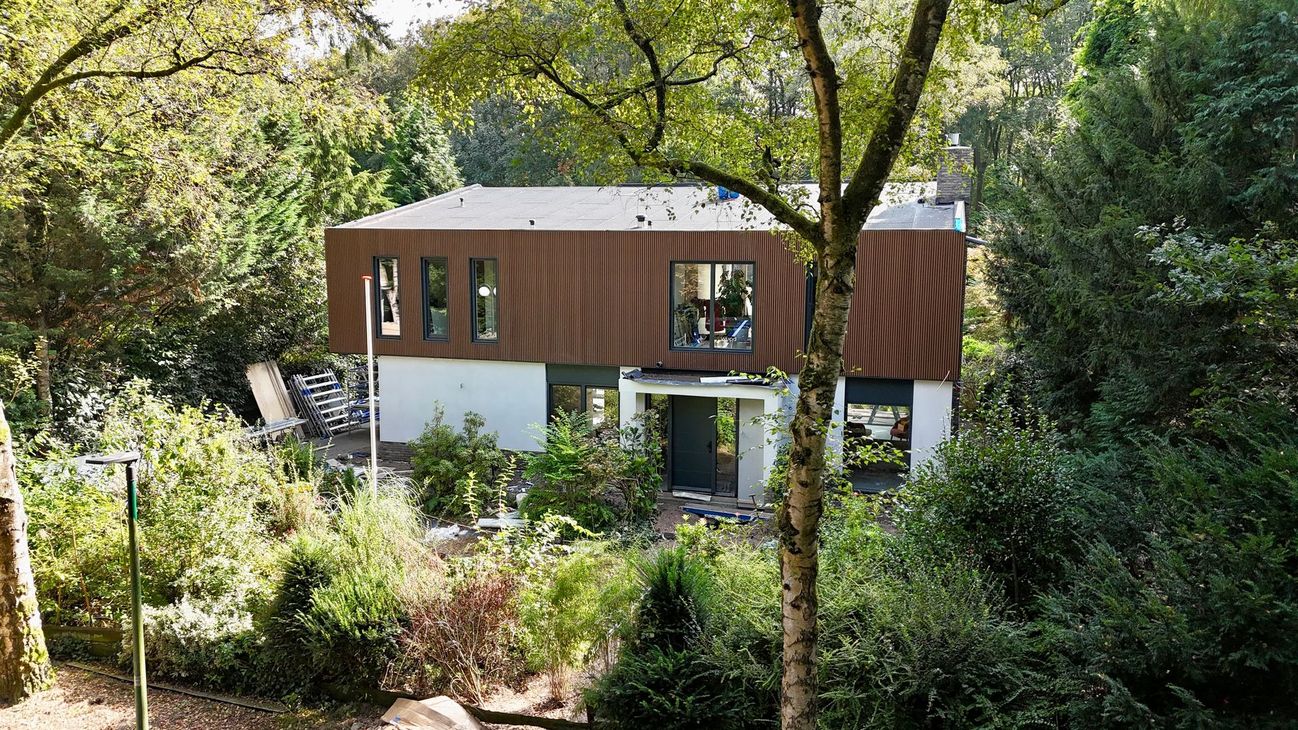 Modern bruin wit bijgebouw in tuin. Gerenoveerde aanbouw woonhuis project.