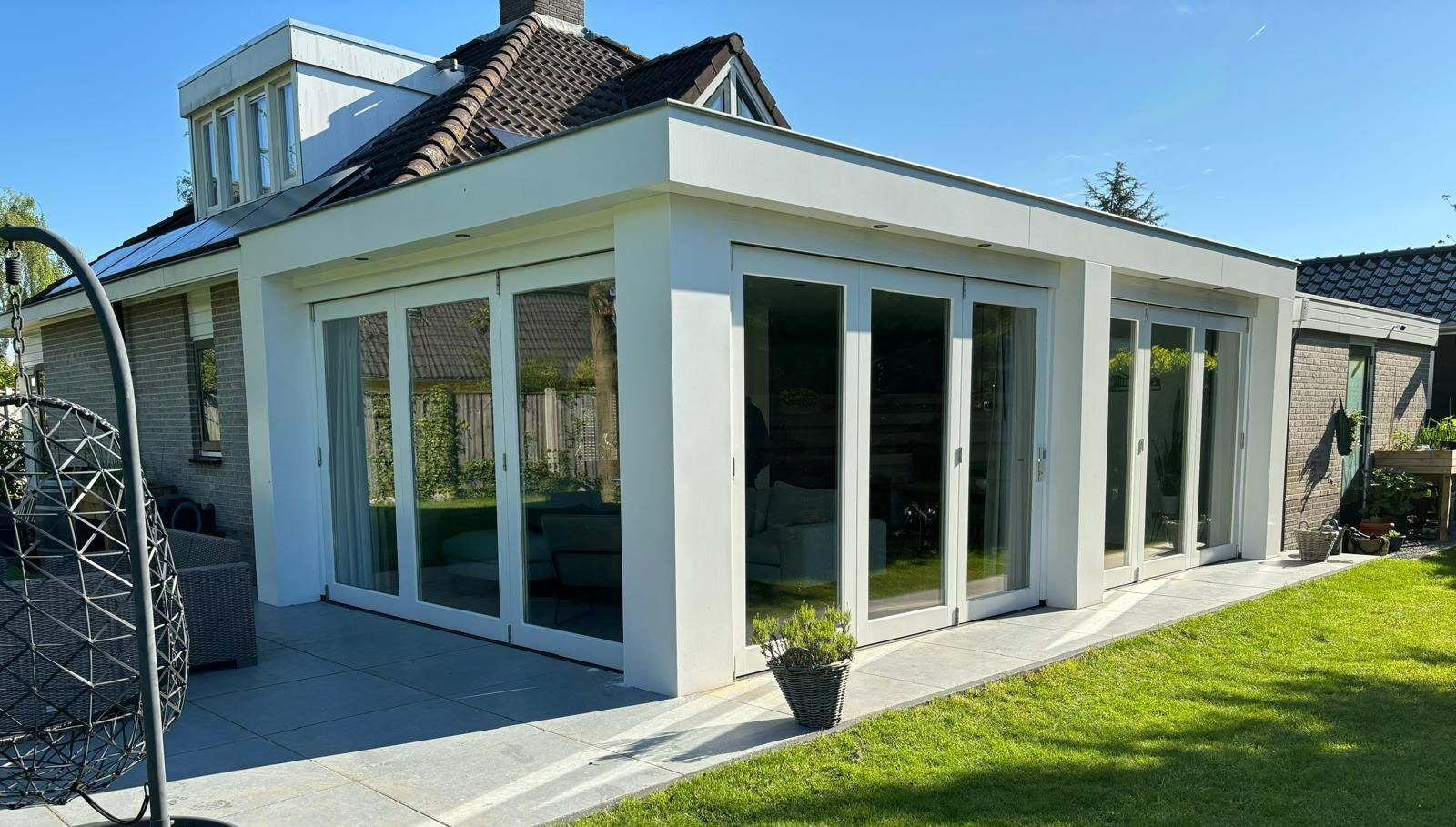 Moderne witte aanbouw gerenoveerd. Verbouwing voorgevel woning.