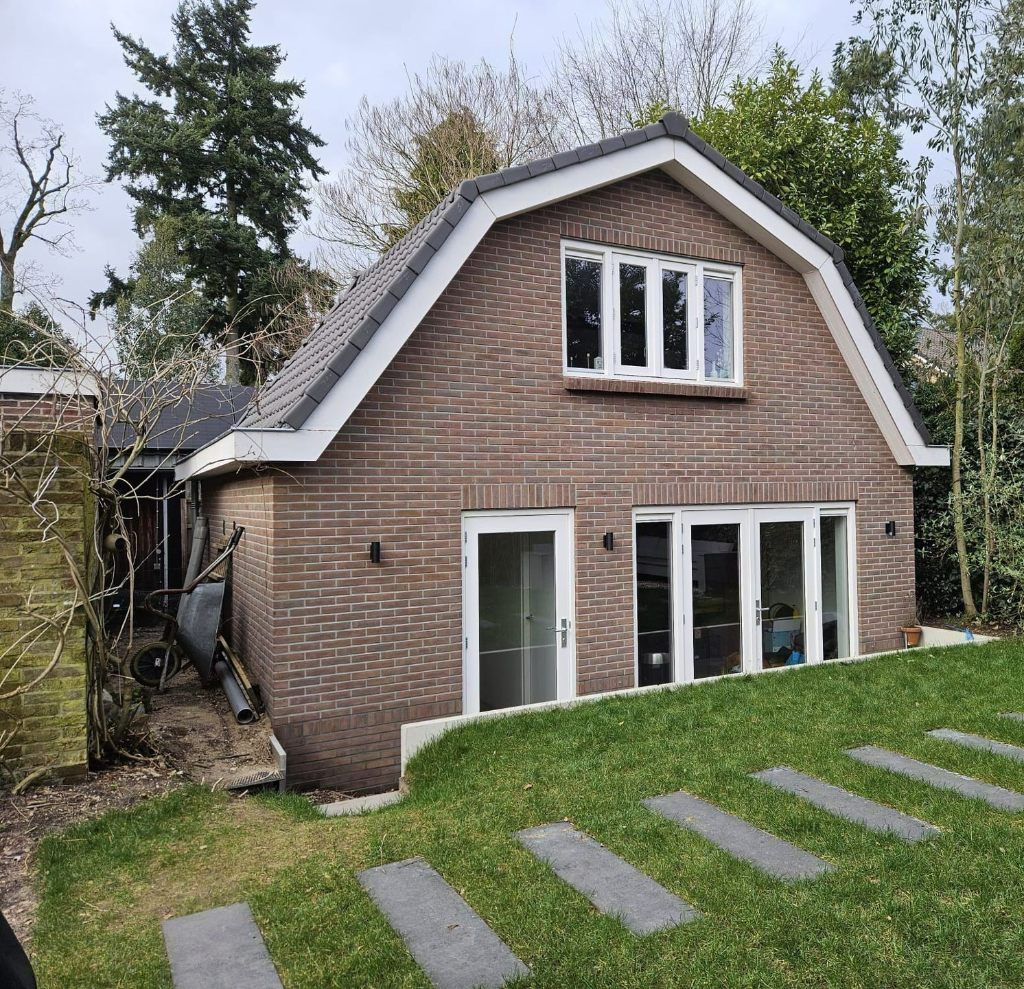 Huis modern voorkant. Witte kozijnen dakwerk. Verbouwing renovatie.