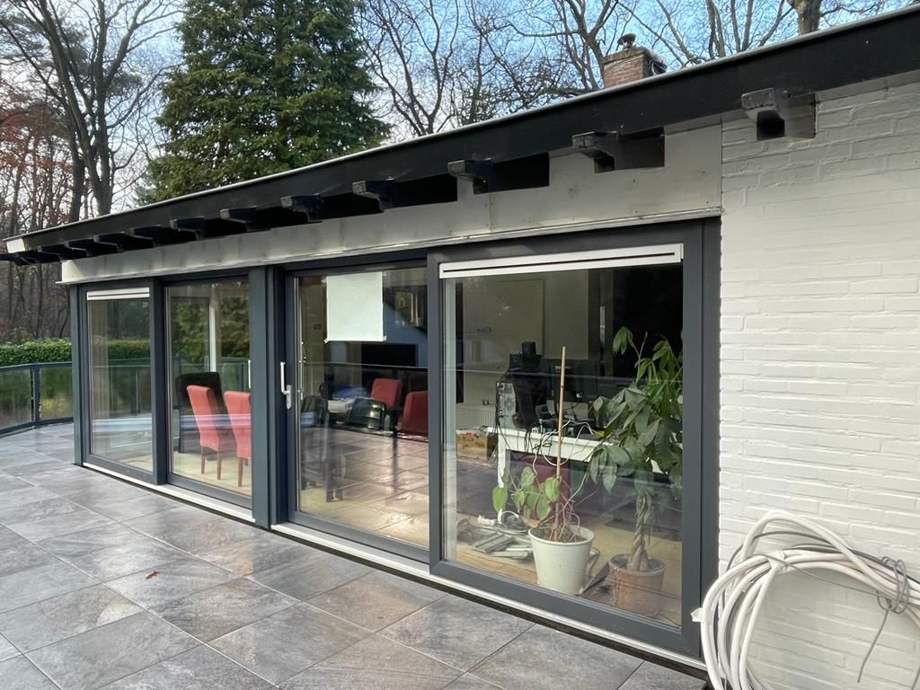 Schuifdeuren naar terras moderne aanbouw. Verbouwing terras en renovatie aanbouw.