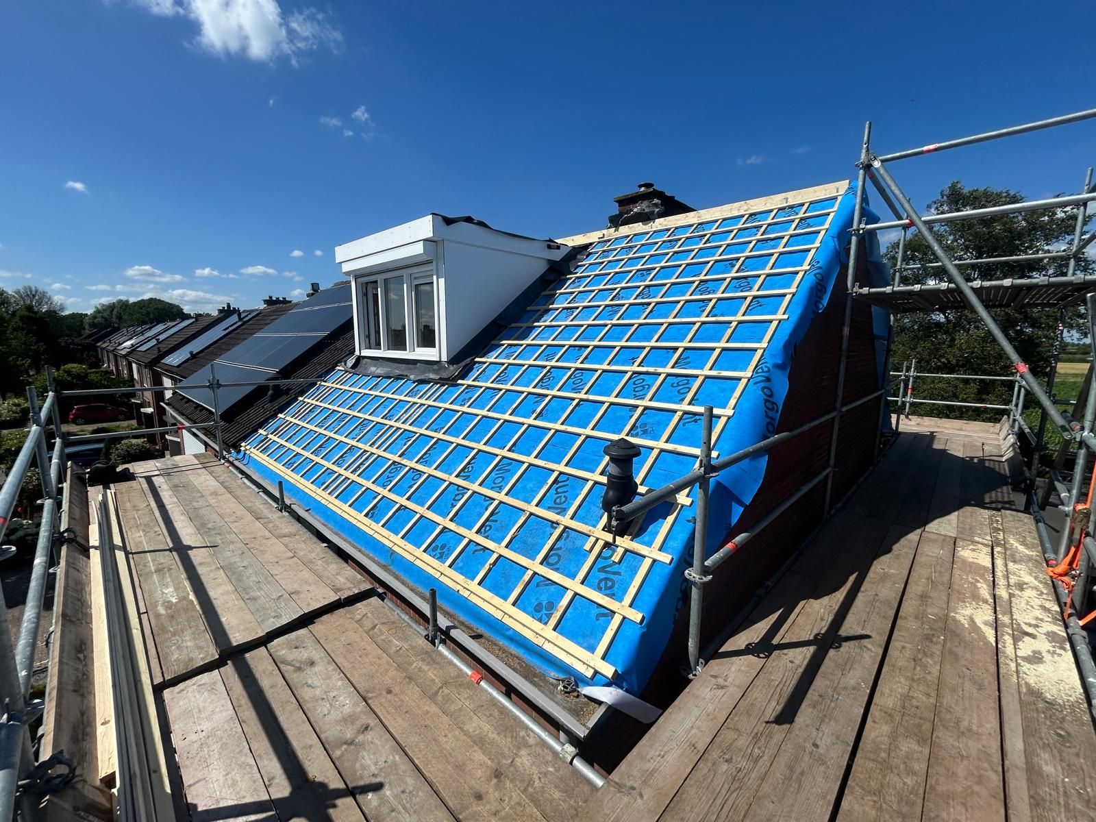 Hellend dak met dakpannen. Dakrenovatie en dakwerk door aannemer in aanbouw.
