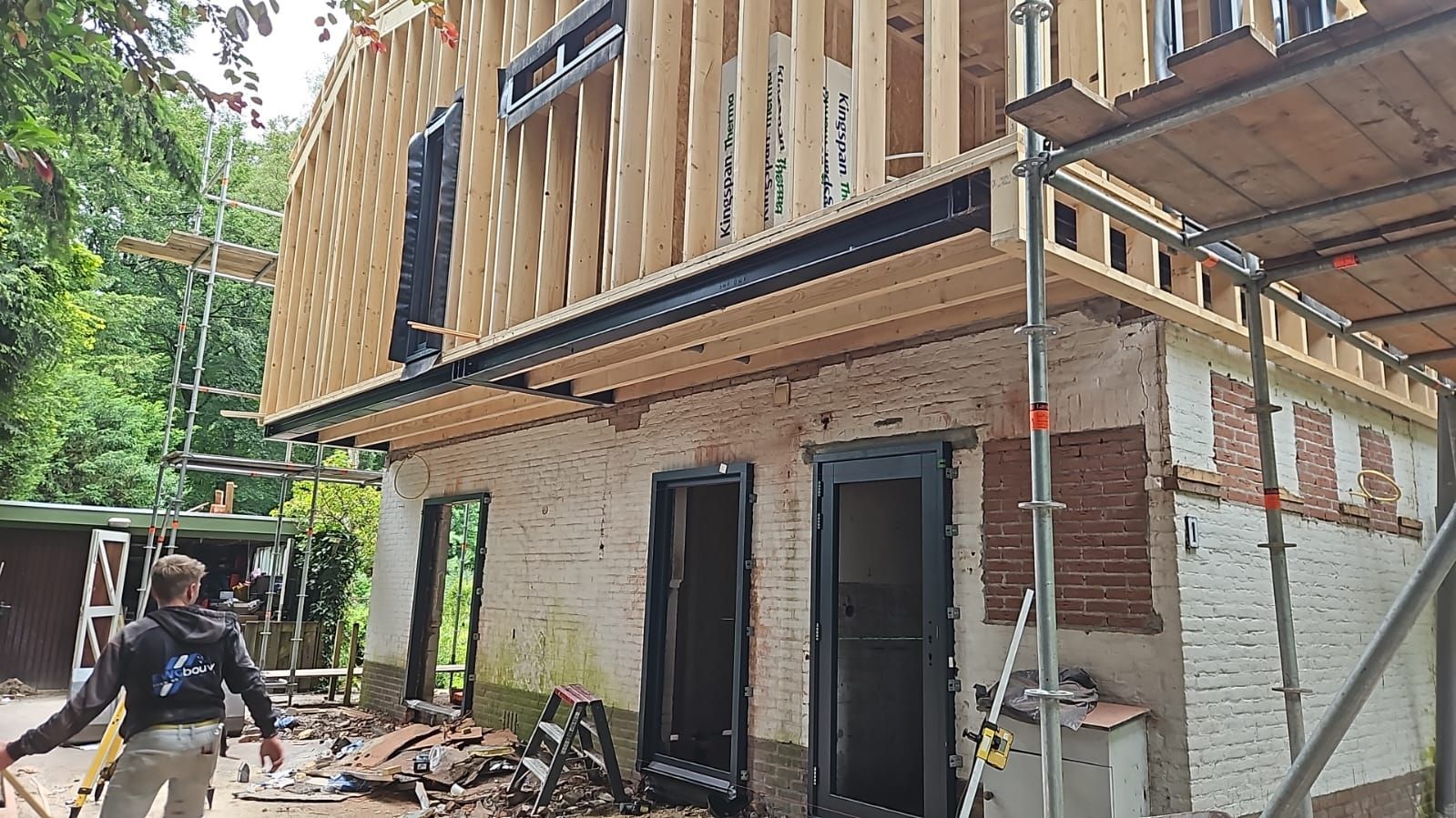 Aanbouw houten gevels met zwarte ramen. 