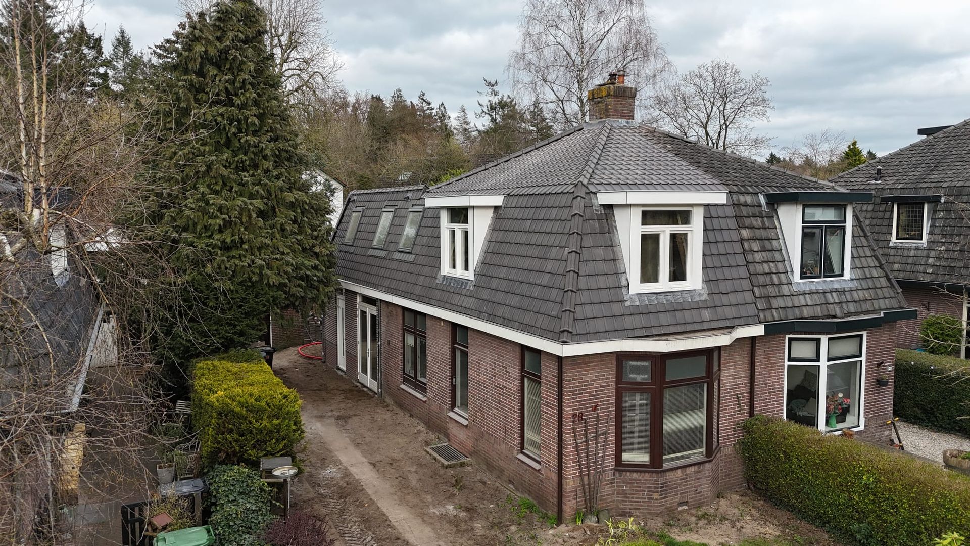Bakstenen huis gevel dak renovatie. Voorgevel verbouwing