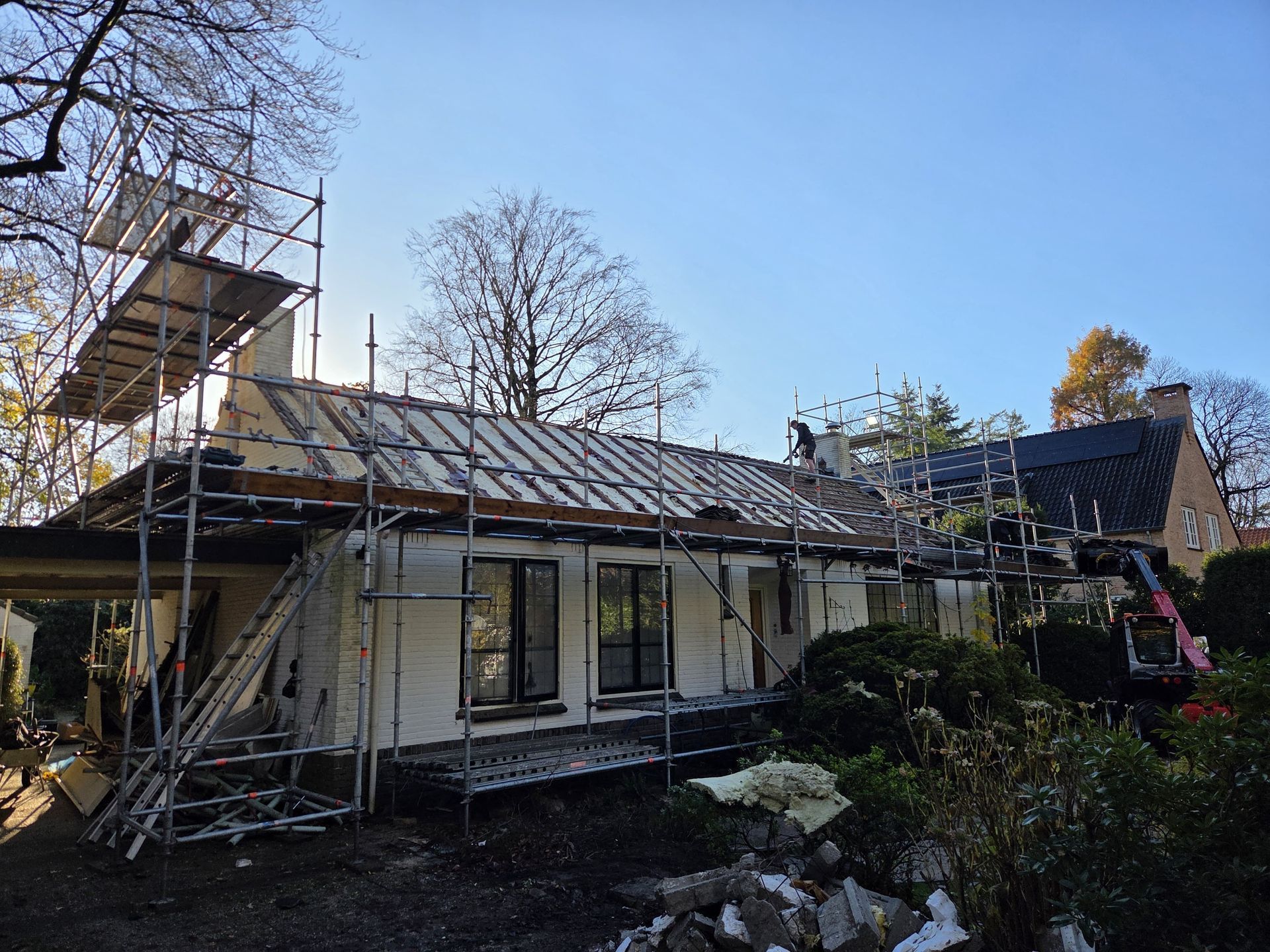 Woning verbouwing in aanbouw. Stellingen witte wanden bouwproces. Renovatie constructie.