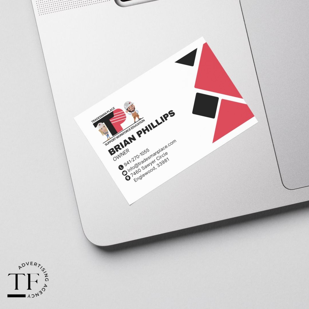 Business card on a silver laptop, featuring black and red geometric accents.