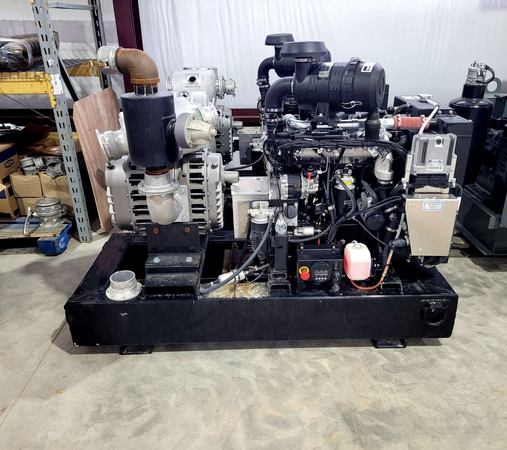 A large engine is sitting on a concrete floor in a warehouse