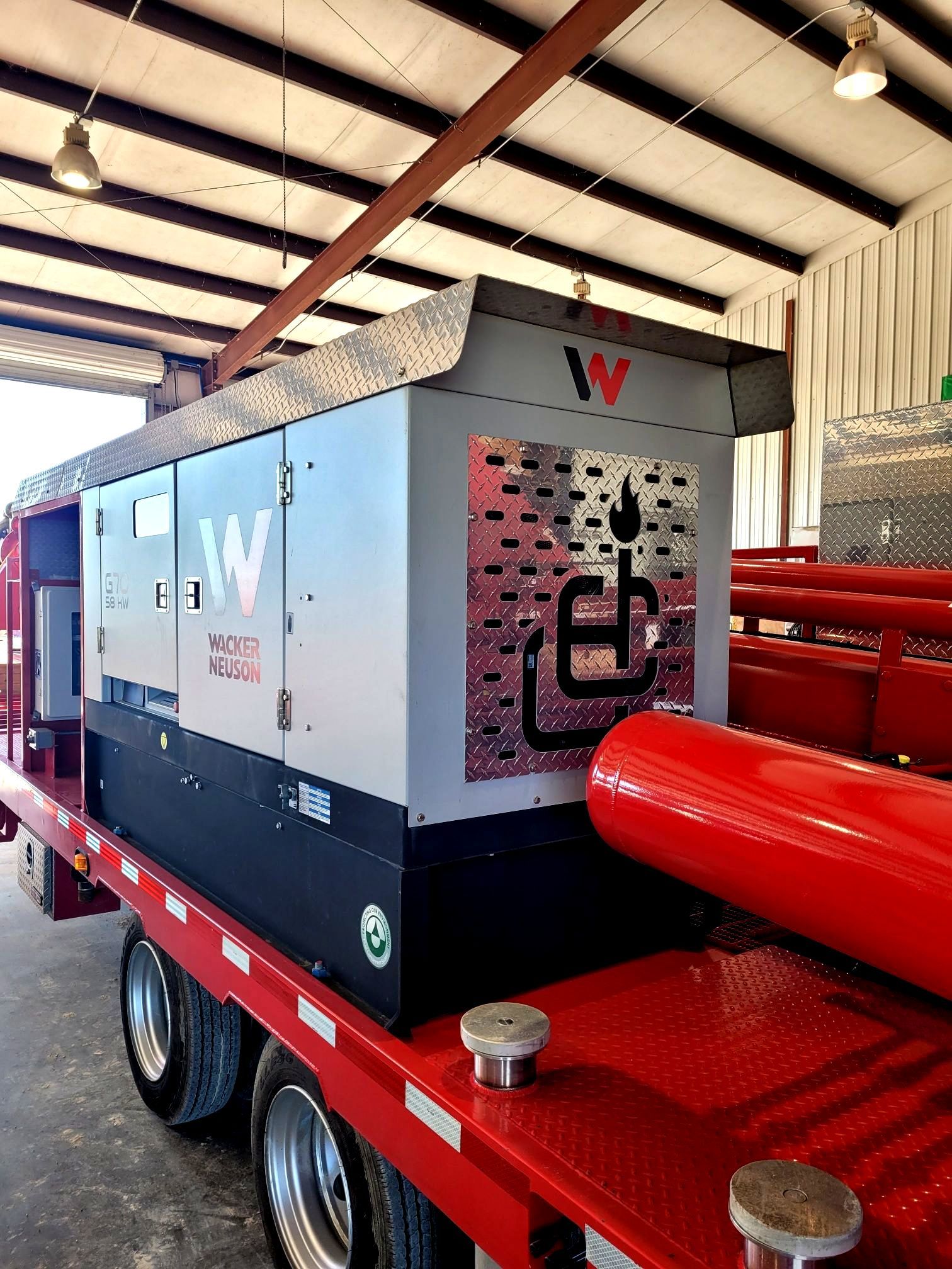 A large machine is sitting on top of a red trailer.