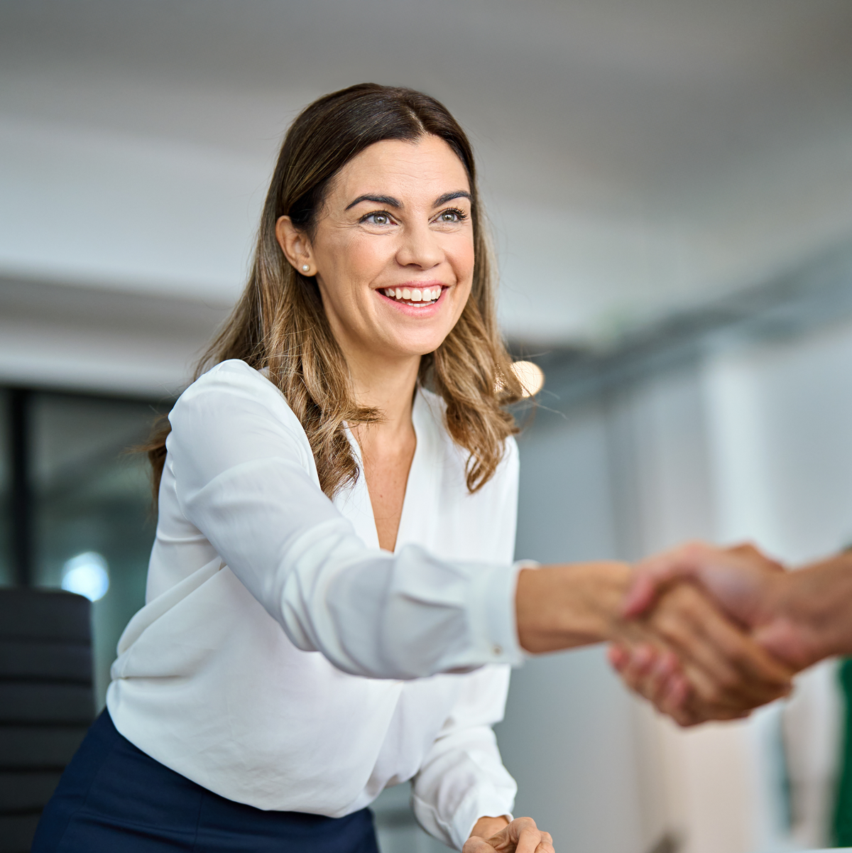 leadmonkey.ai | A woman is shaking hands with a man in an office.