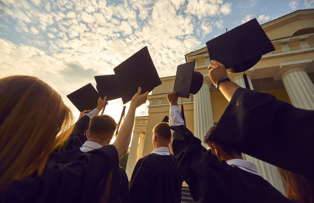 leadmonkey.ai | A group of graduates are holding their caps in the air.