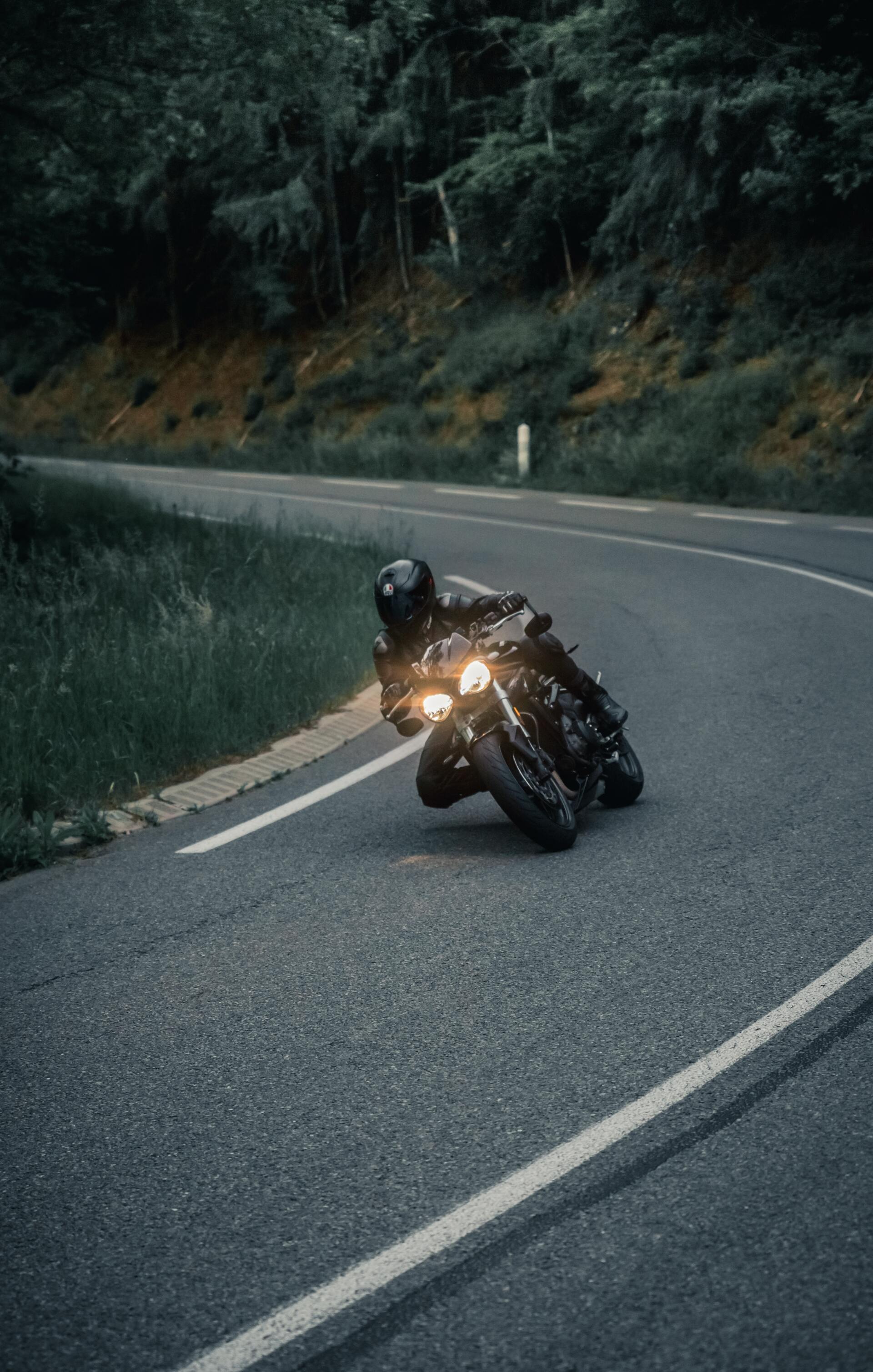 A man is riding a motorcycle down a curvy road.