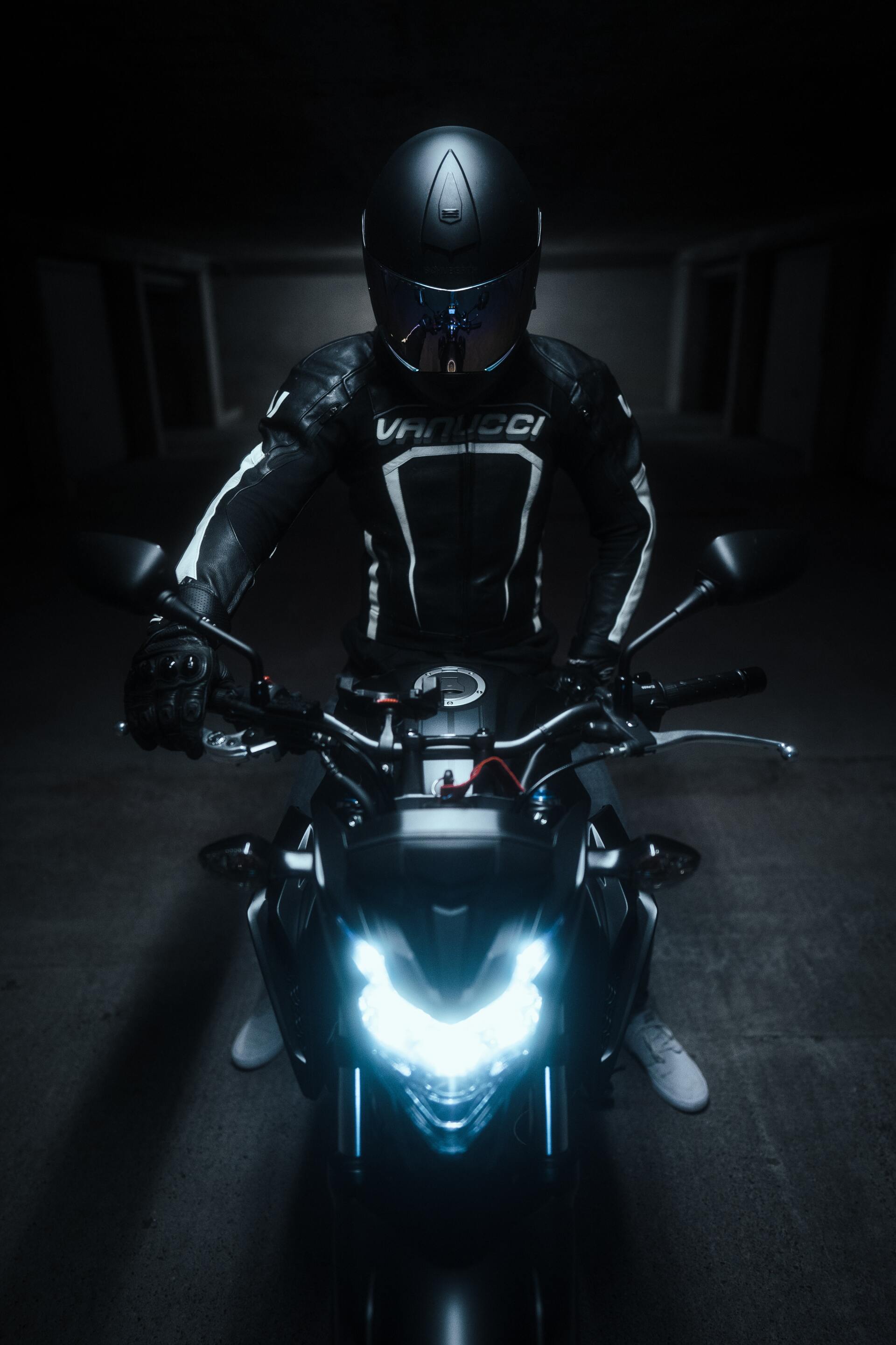 A man is riding a motorcycle in the dark.