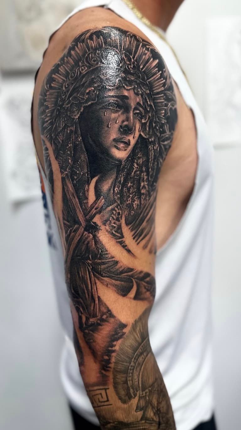 Arm tattoo sleeve depicting a detailed portrait of a woman with dark hair and floral elements
