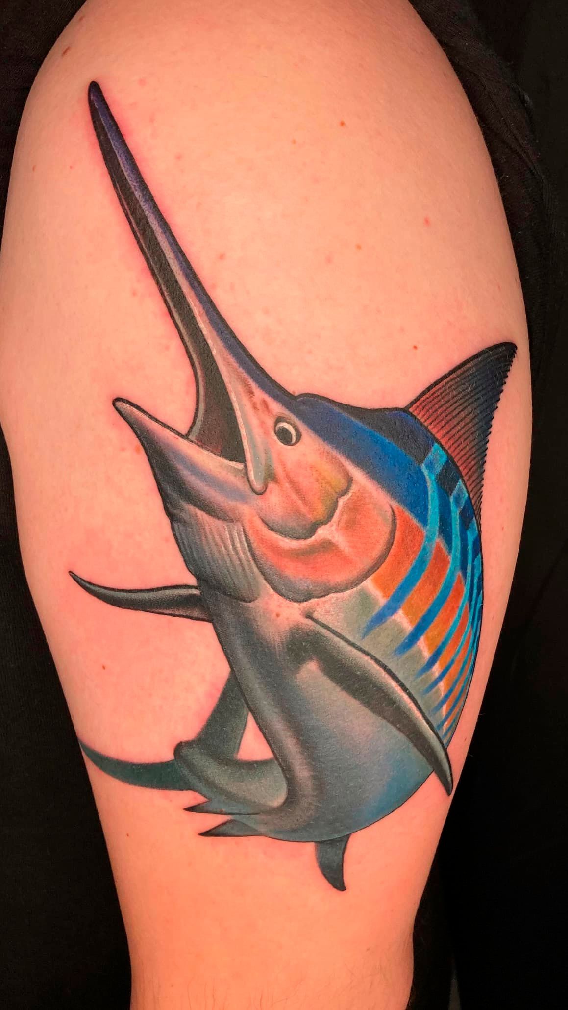 Marlin tattoo with blue and orange stripes on an upper arm