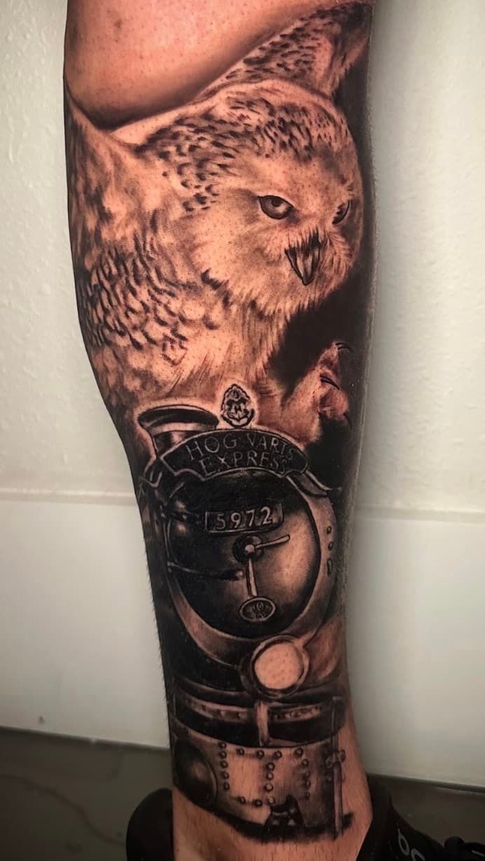 Black-and-gray tattoo sleeve with an owl above an Egyptian pharaoh mask on a forearm