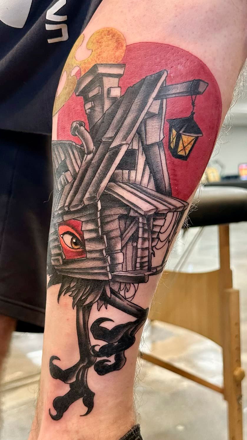 Forearm tattoo of a detailed ship against a red background, with an anchor and lantern.