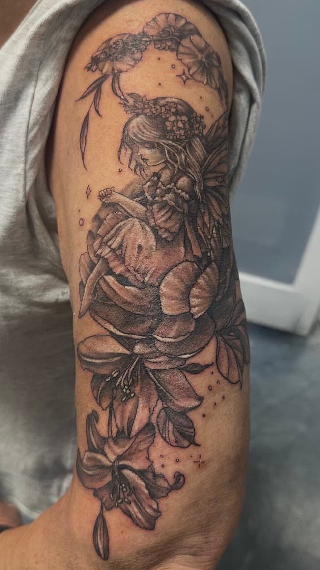 Close-up of a forearm with a detailed black-and-gray floral tattoo design
