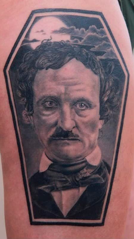 Black-and-gray portrait tattoo of a stern man in a coffin-shaped frame with clouds above