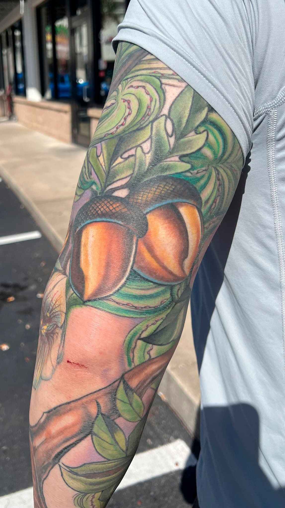 Close-up of a colorful floral tattoo on a person’s upper arm