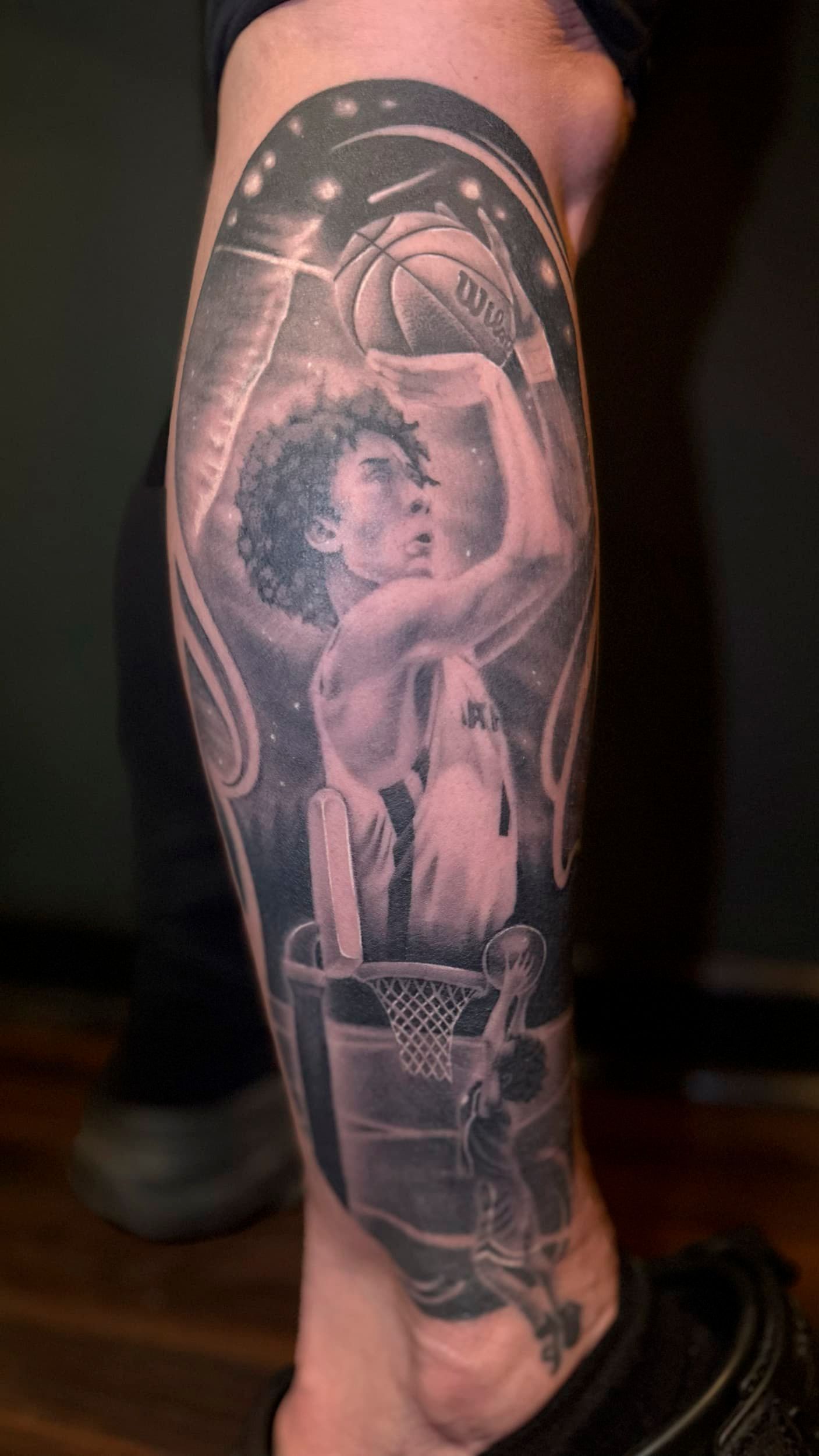Black-and-gray tattoo sleeve featuring a woman, abstract swirls, and ornate details on a leg
