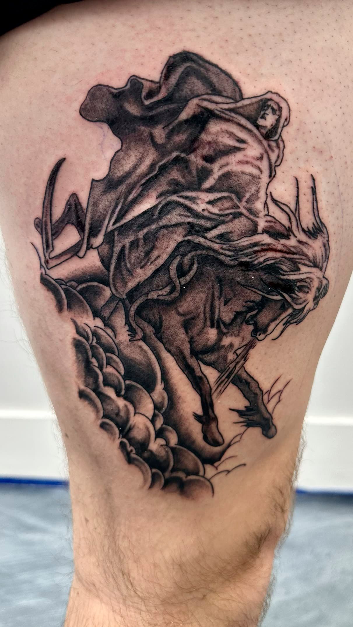 Black-and-gray tattoo of a roaring lion on a person’s calf