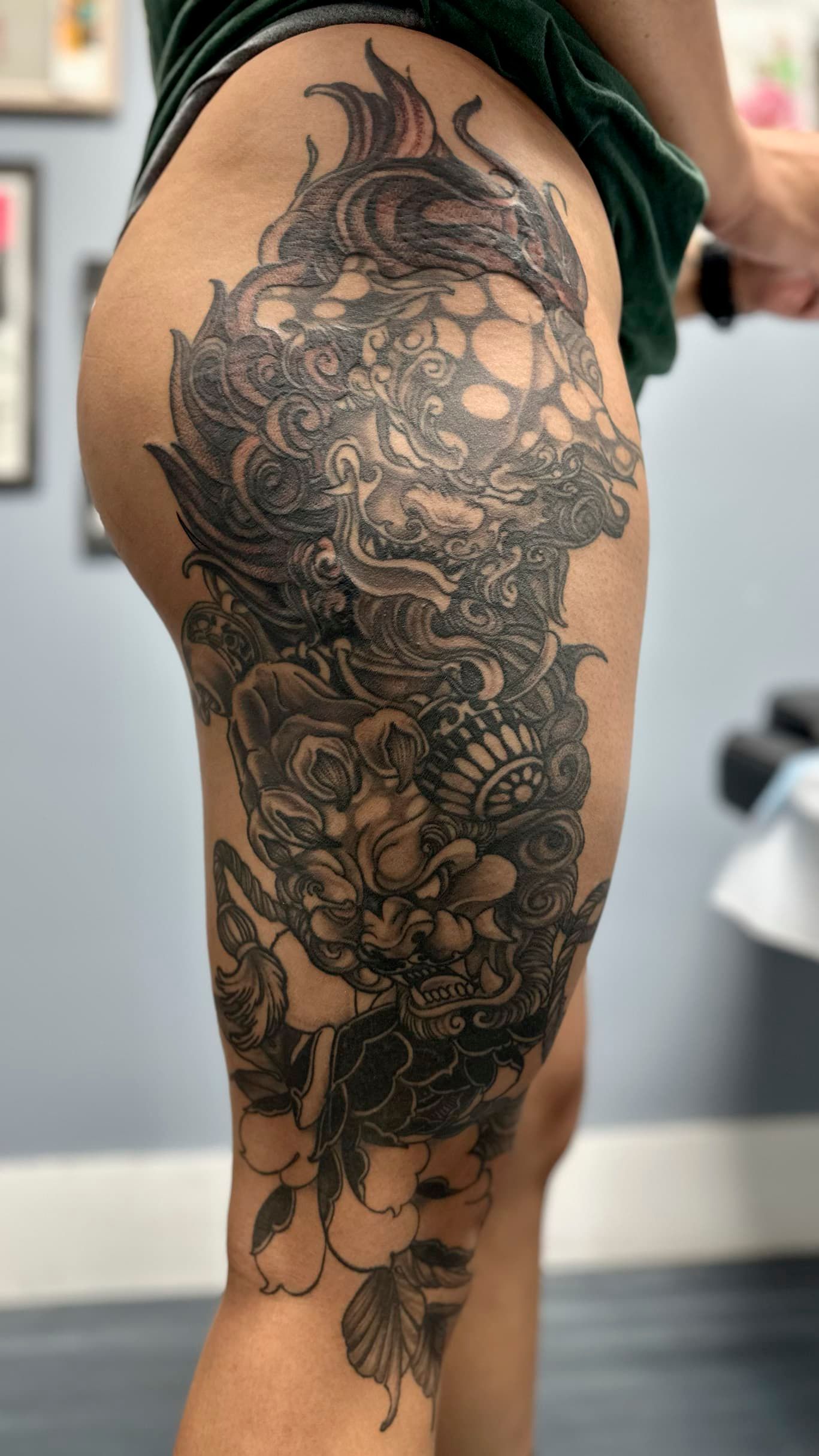 Black floral and geometric tattoo sleeve on a person's upper arm, side view