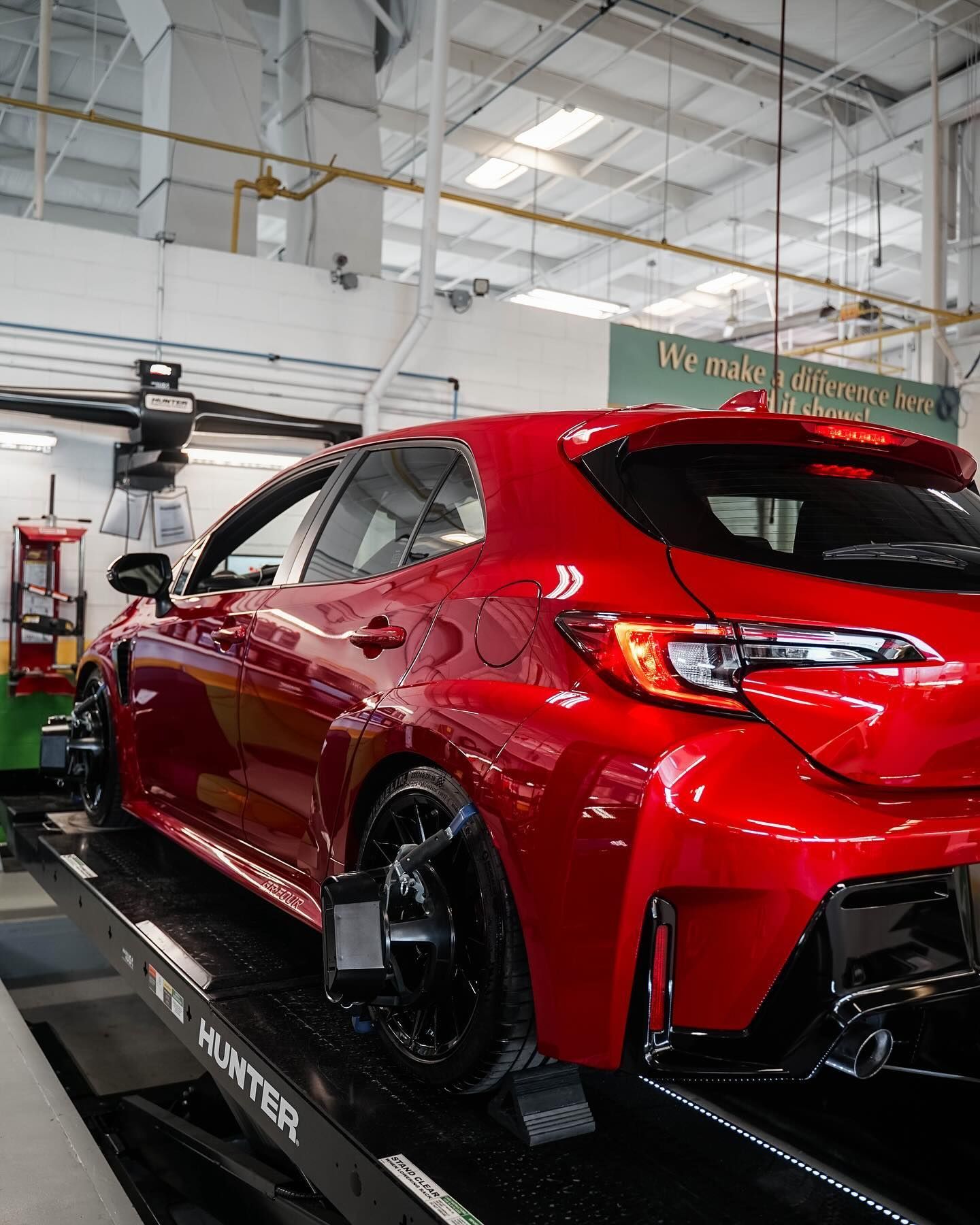 Technician Inspecting Red SUV Inside Repair Bay | D&V Autobody Overland