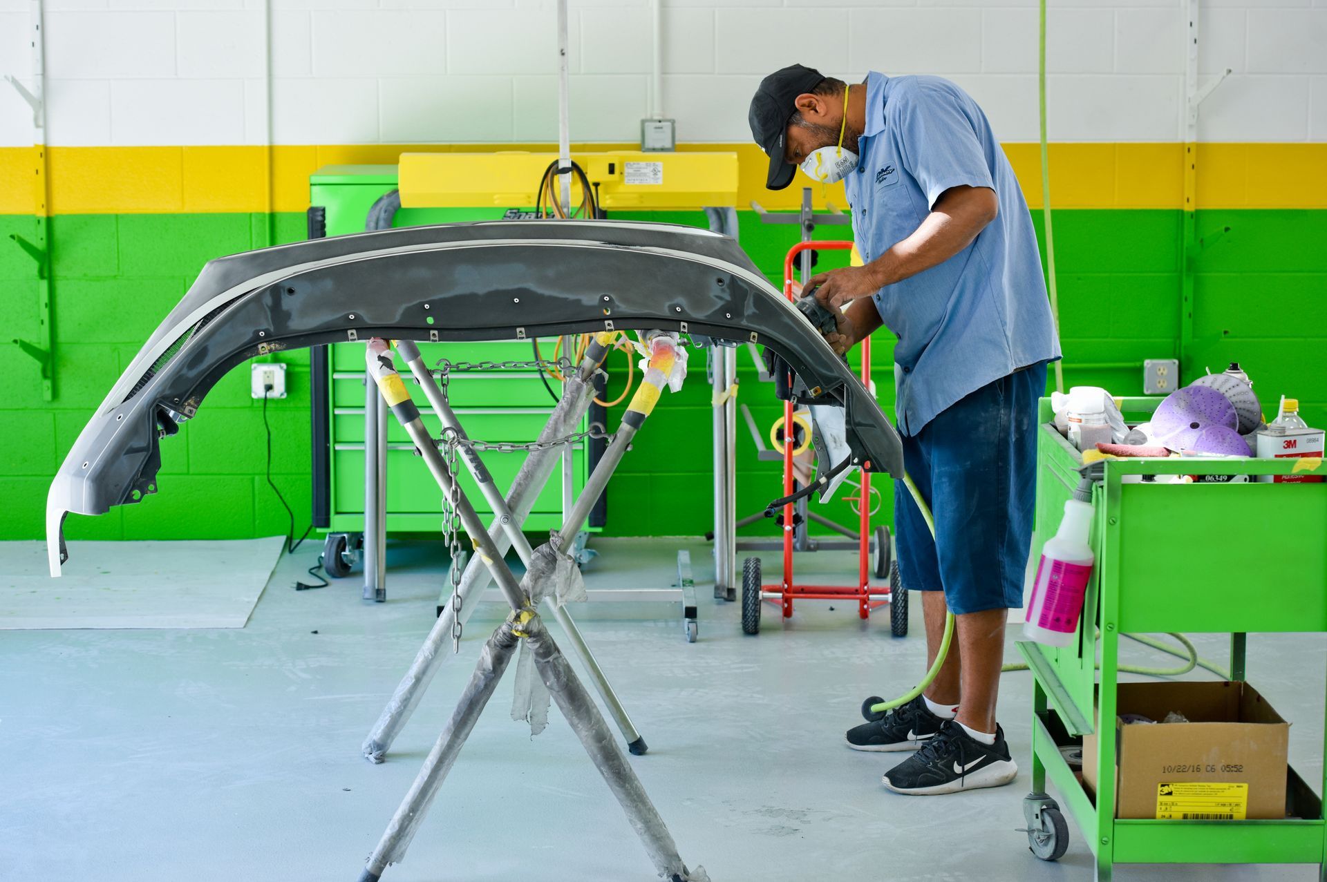 Mechanic Repairing Vehicle Bumper With Hand Tools | D&V Autobody