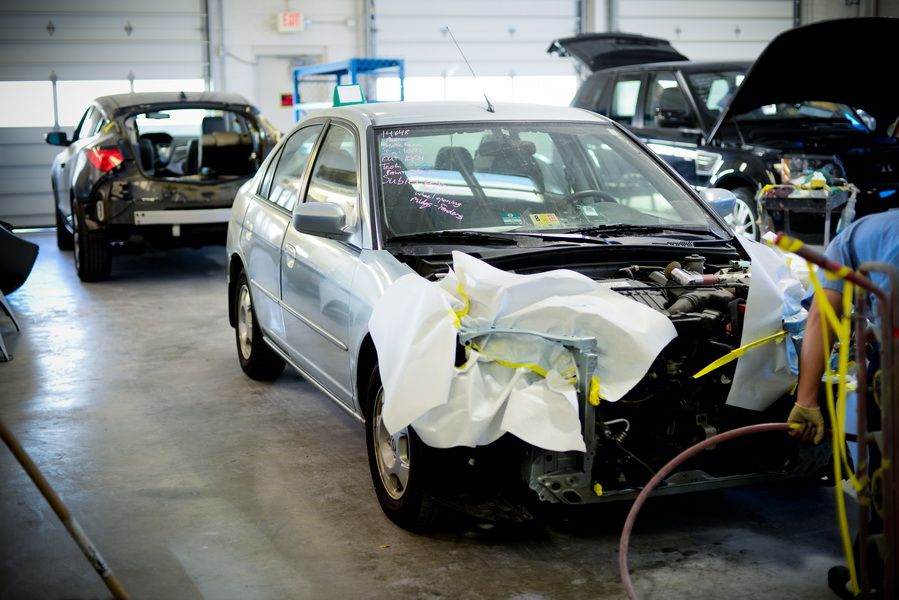 Damaged White Sedan Prepared For Auto Body Repair | D&V Autobody